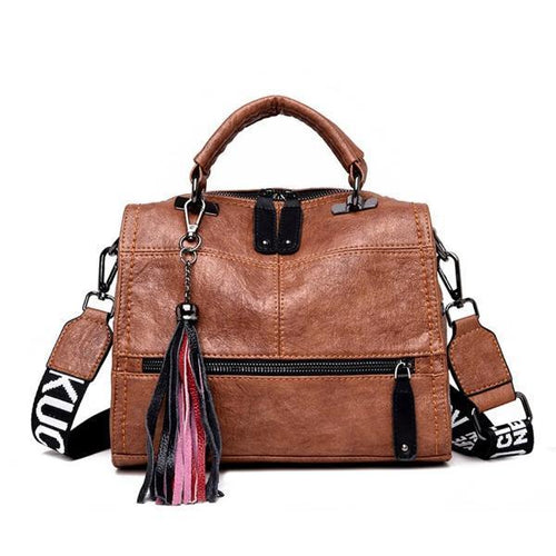 Brown crossbody leather bag with front zipper pocket and tassles